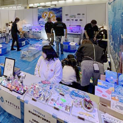 室内に青いビニールシートが敷かれ、海や川の生物と触れ合えるゾーンやグッズが販売されている受付がある。