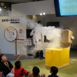 段ボールで作られた空気砲で真っ白な煙の輪っかを飛ばすショーの様子
